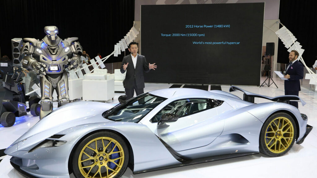 A trade Show stand with the international entertainer 'Titan the Robot' acting as a keynote speaker with 2 other presenters. The worlds fastest electric hyper car - the Aspark Owl - is in the foreground
