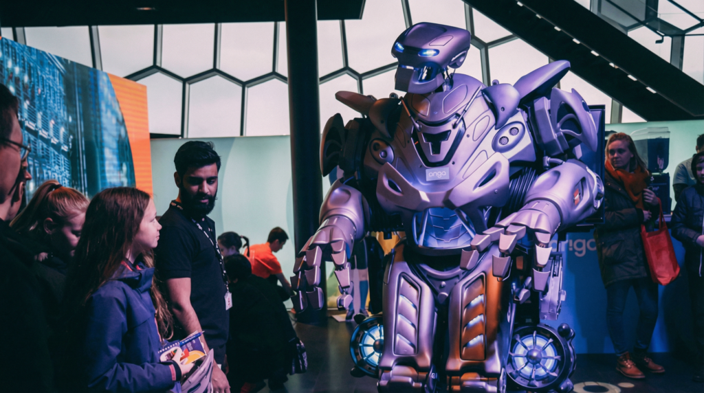titan the robot stares down at a young audience member in a dark room at a corporate event in iceland