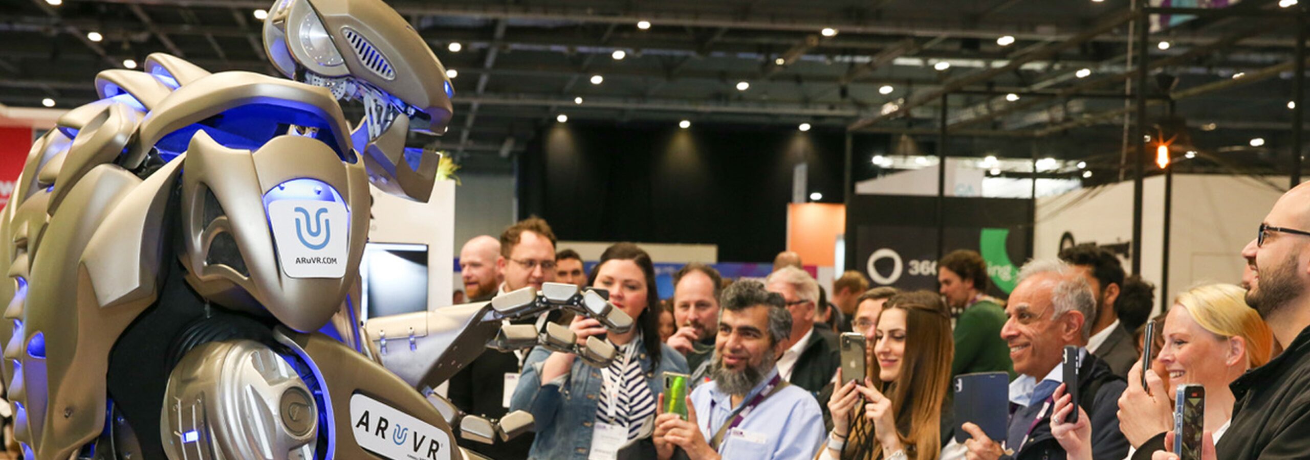 Titan the robot, up close and personal with a crowd of trade show attendees, all taking pictures and looking amazed