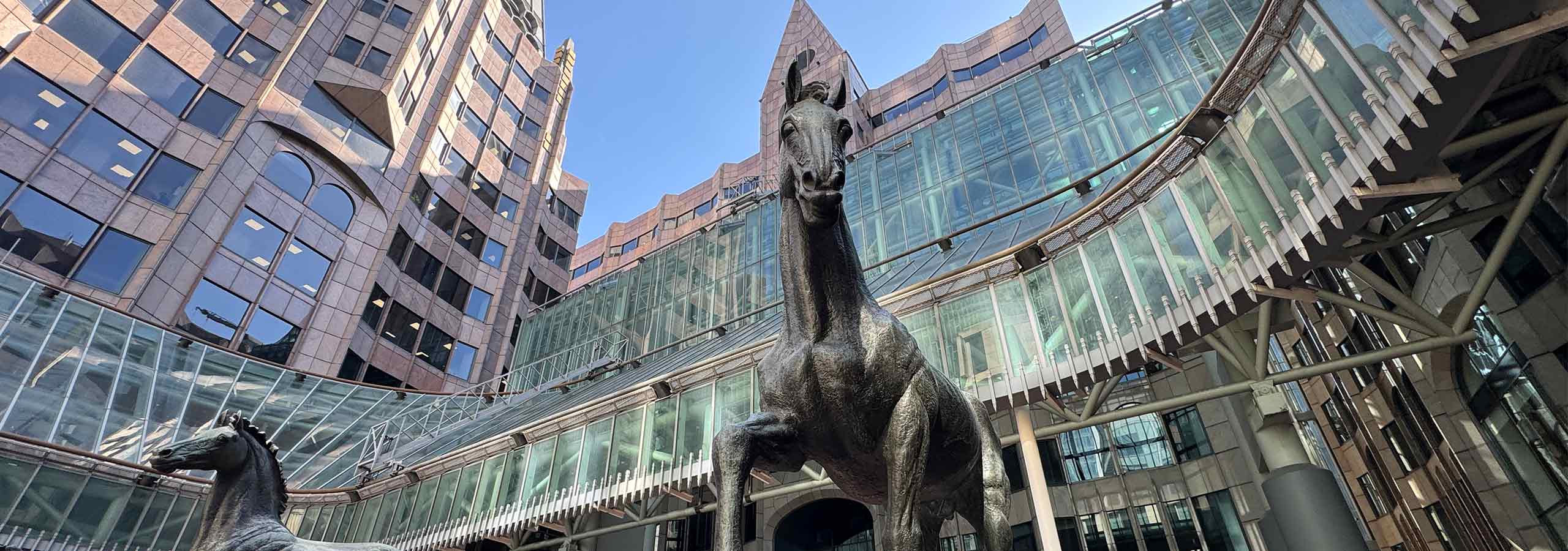 The statue of a horse standing tall over the camera, with the Minster Building in London, behind.