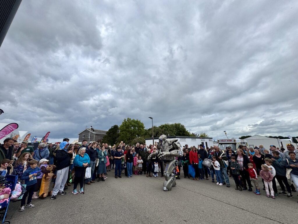 titan performs his standard show to a large, semi circle crowd. the sky is dark and cloudy.